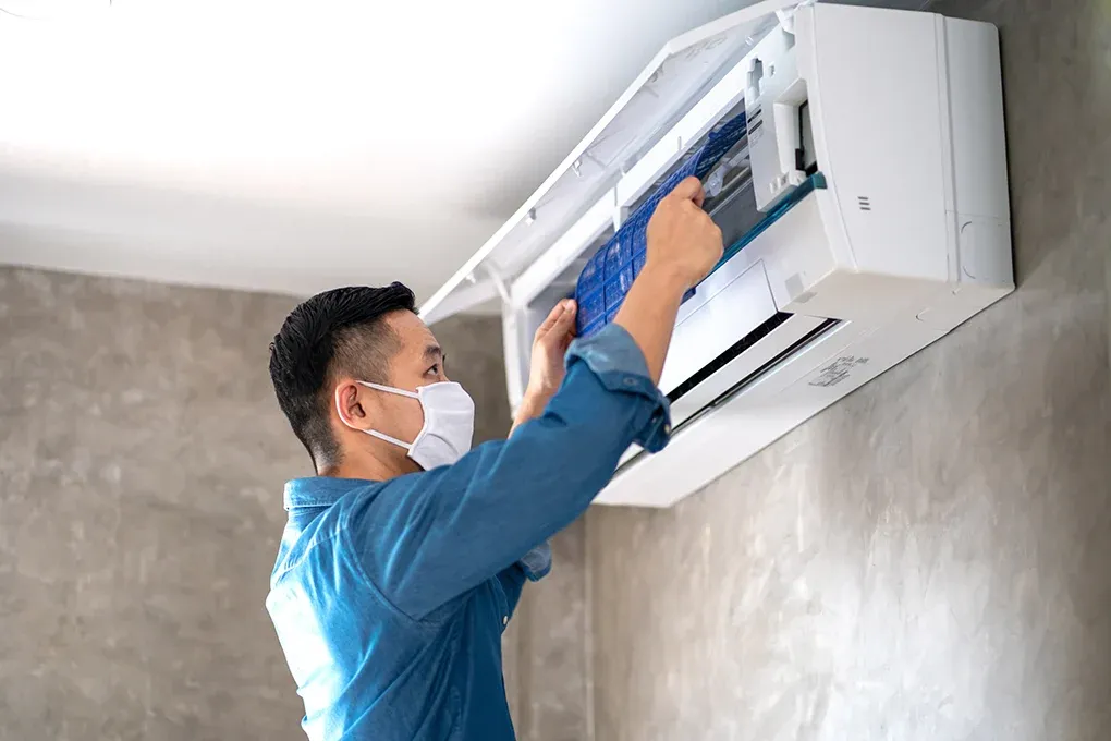 A technician taking out an aircon filter for cleaning