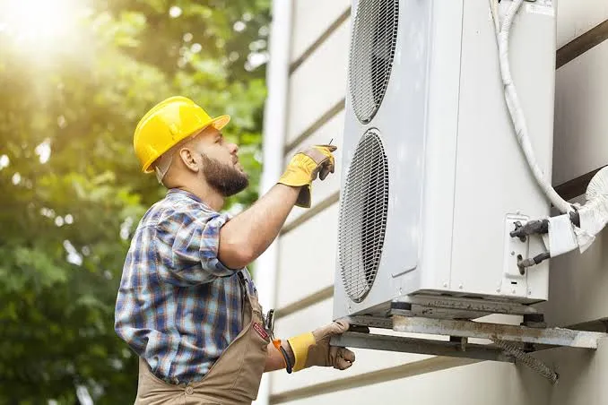A technician installing an aircon outdoor unit